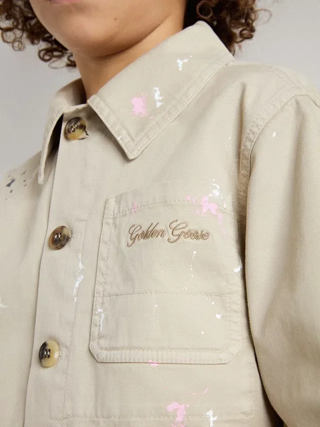 Beigefarbene Kinderjacke mit bunten Farbtupfern