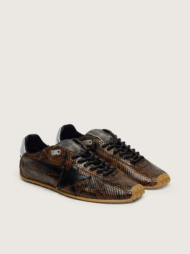 Damen-Modell „Marathon Speed“ aus Leder mit braunem Schlangenprint, schwarzem Stern und silberner Lederlasche an der Ferse