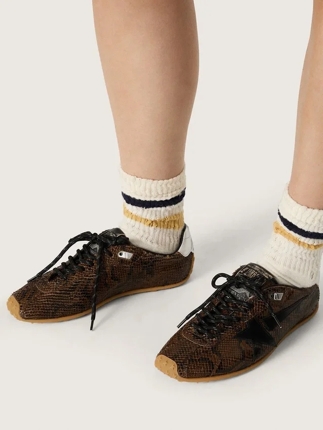 Damen-Modell „Marathon Speed“ aus Leder mit braunem Schlangenprint, schwarzem Stern und silberner Lederlasche an der Ferse