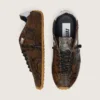 Damen-Modell „Marathon Speed“ aus Leder mit braunem Schlangenprint, schwarzem Stern und silberner Lederlasche an der Ferse