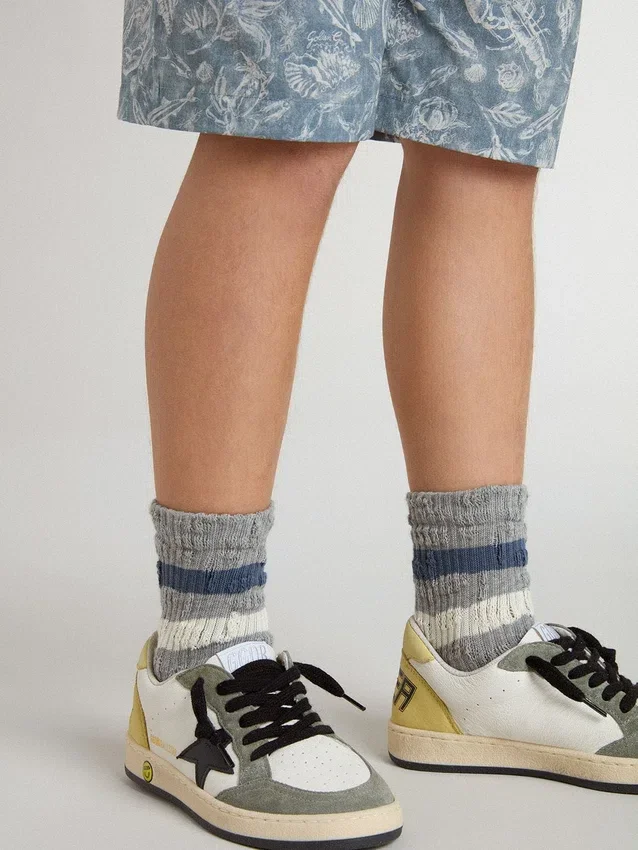 Graue Kindersocken mit Used-Look-Details und abgenutzten weißen und blauen Streifen