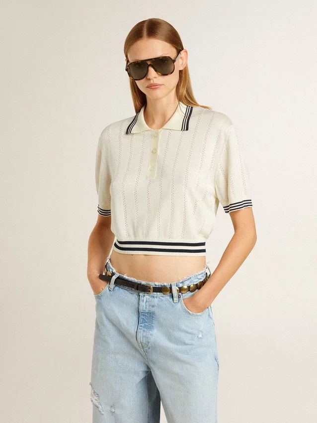 Kürzliches, im Used-Look gehaltenes Damen-Polohemd aus weißer Baumwolle mit blauen Rippbündchen