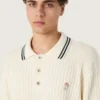 Langärmliges Herren-Poloshirt aus weißem Strick mit kontrastierenden Kanten und abnehmbarer Anstecknadel