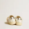 May Young mit fuchsiafarbenem Glitzerstern und Absatzlasche aus Metallic-Leder