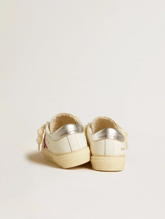 May Young mit fuchsiafarbenem Glitzerstern und Absatzlasche aus Metallic-Leder
