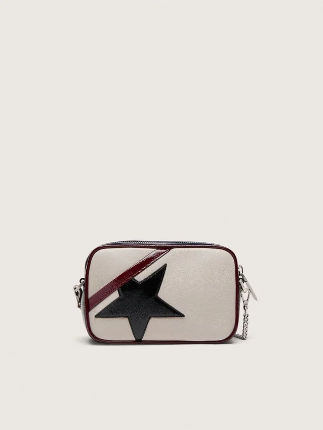 Mini Star Bag aus butterweißem Leder mit schwarzem Stern und burgunderroten sowie dunkelblauen Details