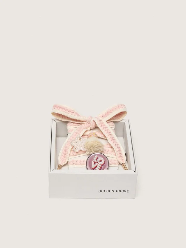 Schnürsenkel aus Lederwaren in Hellbeige mit rosa Zierband, Anstecknadel und Applikationen