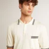 Weißes, im Used-Look gehaltenes Strick-Poloshirt für Herren mit blauen Rippbündchen